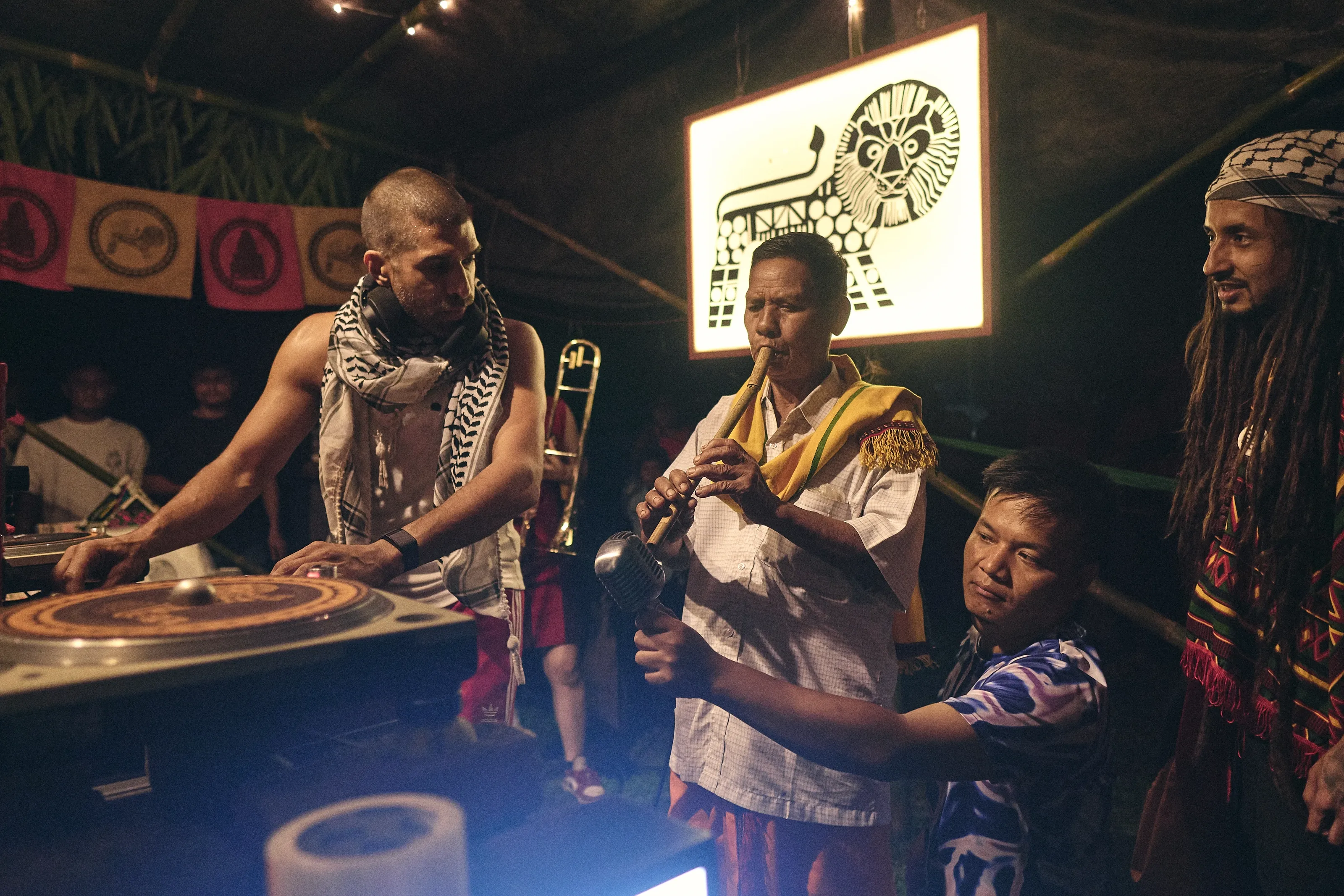 DJs and musicians performing at the BFR sound-system booth beneath the lit lion-crest sign
